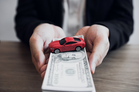 汽车销售人员向客户提交现金和型号汽车图片