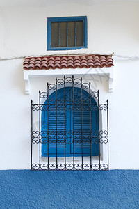 在摩洛哥Asilah用蓝色百叶窗和金属护栏保的传统摩洛哥窗口图片
