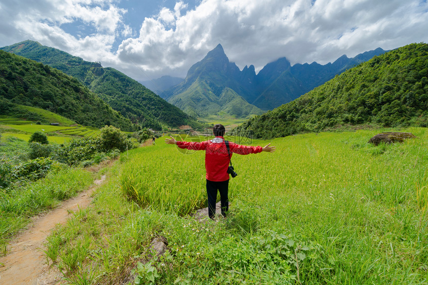 一名亚洲旅游男子在越南萨帕Sapa的旅游行和假期概念中夏季在Fansipan山上与稻田谷一起观望图片