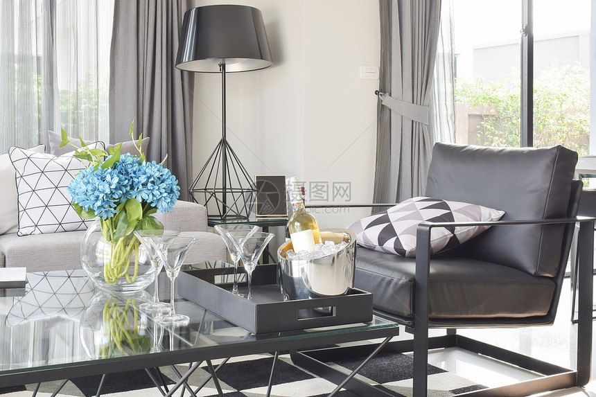 现代客厅玻璃最上桌的黑皮椅和酒图片
