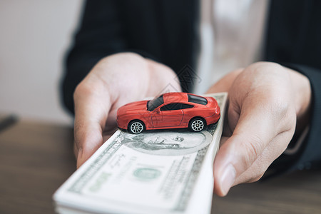 汽车销售人员向客户提交现金和型号汽车图片