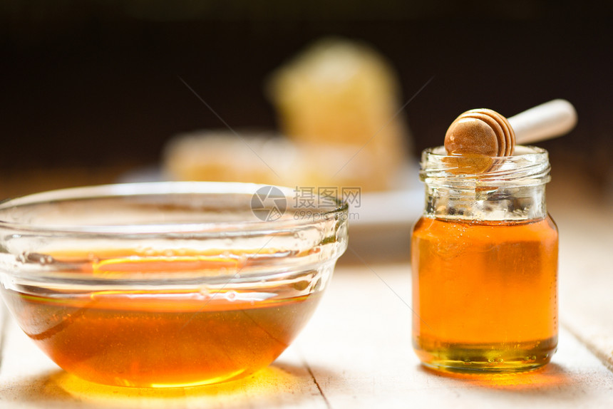 新鲜蜂蜜健康食品关闭碗中的黄蜂蜜和加瓶玻璃中的黄蜂蜜底漆上装有木花的玻璃罐复制空间图片
