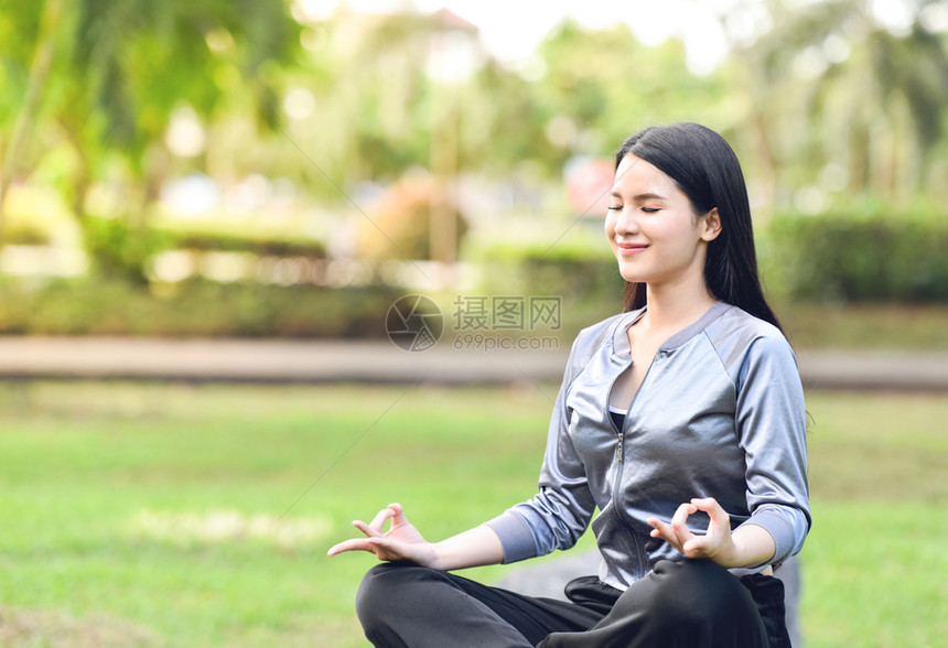 漂亮女青年在户外公园绿草地上做瑜伽放松冥想
图片
