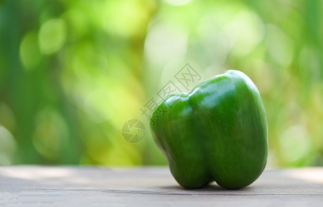 木和自然绿色背景上的新鲜绿色甜胡椒图片