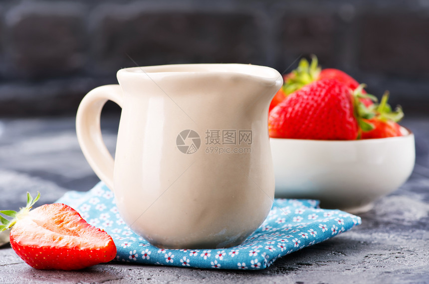 茶壶和草莓中的牛奶图片