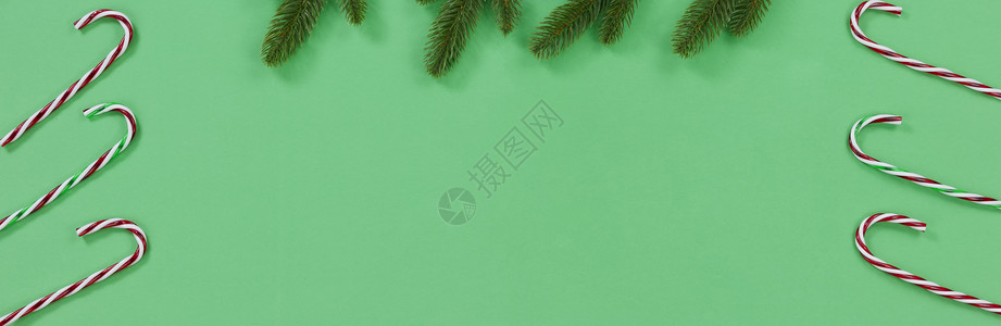 绿色背景有圣诞季节的糖果甘蔗和fir树枝图片