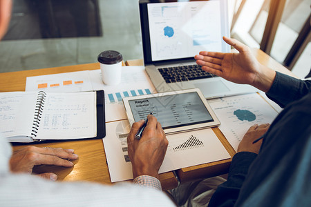 企业伙伴关系共同工作人员分析成本工作进度使用平板块来图表公司财务预算报告和在办公室的未来规划背景