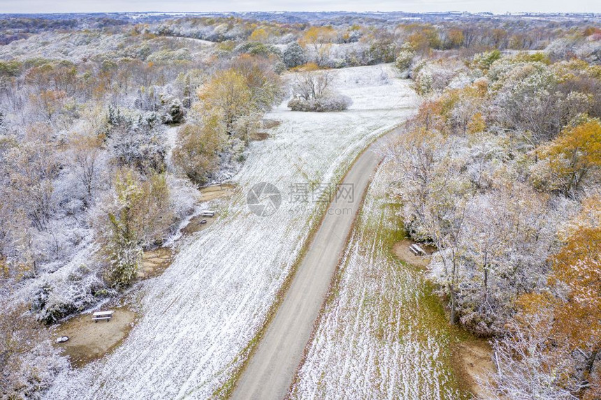 在密苏里西部的蜜溪保护区空中观测到早期积雪的灰尘下砍伐森林和收获的玉米田图片