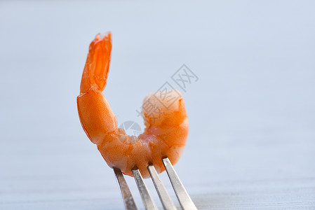 叉上的虾煮海鲜以餐桌背景的叉子为餐桌背景的海洋美食晚餐图片