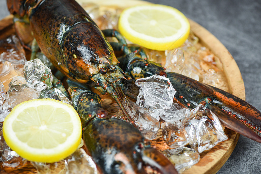 在海鲜餐厅的新龙虾贝壳鱼用于煮熟食品在黑石桌上的冰和柠檬生龙虾有选择地聚焦图片