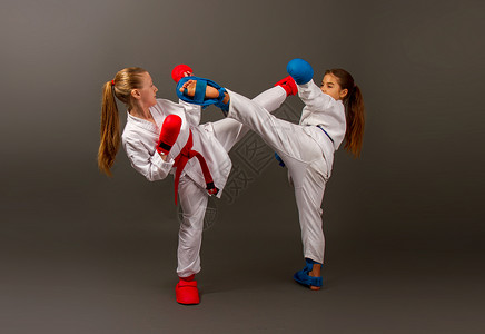在基莫诺斯两个小空手道女孩和全套运动保护装备红和蓝色战斗与黑暗背景空手道女孩花公子背景图片