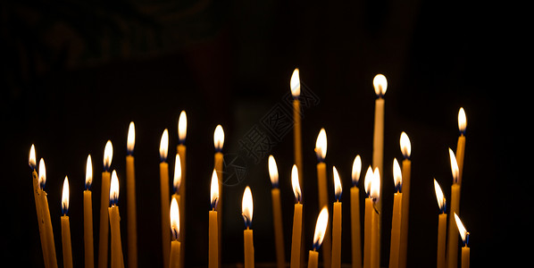 黑色背景下燃烧的蜡烛装饰背景图片