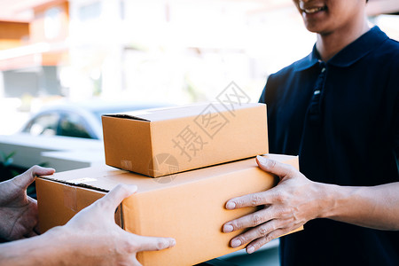 亚洲货运承人持有一个纸箱里面装着货包接收方正在签署货包男人高清图片素材