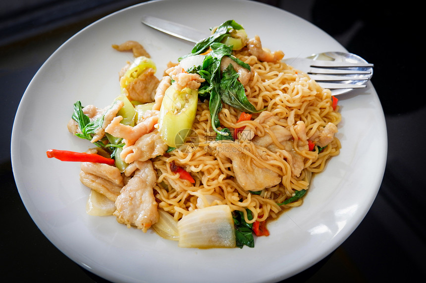 即时面在白盘上方的头顶视图泰国式食物面上即时炒鸡肉辣椒和叶泰国式面条图片
