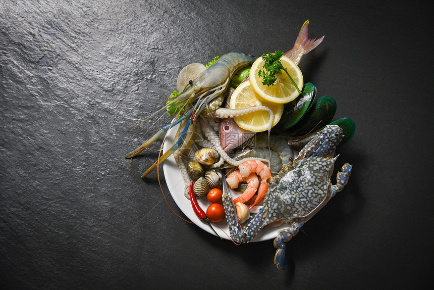 贝壳鱼海鲜板和虾蟹壳鱿鱼和海和洋美食晚餐新鲜生海底有草药和香料柠檬图片