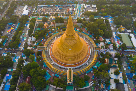 日落时的法拉路德玛迦迪寺庙空中最顶端景象带有住宅的金佛塔泰国纳科恩路德姆区城市圣泰建筑背景图片