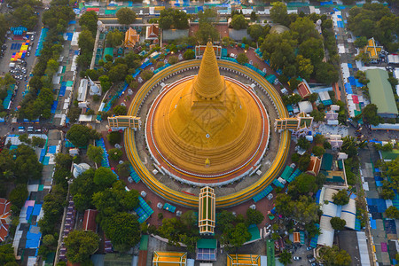 日落时的法拉路德玛迦迪寺庙空中最顶端景象带有住宅的金佛塔泰国纳科恩路德姆区城市圣泰建筑背景图片