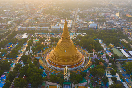 日落时的法拉路德玛迦迪寺庙空中最顶端景象带有住宅的金佛塔泰国纳科恩路德姆区城市圣泰建筑背景图片