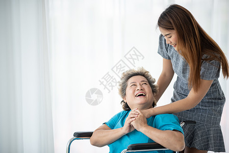 微笑和说话照顾者微笑在她的同时与老年妇女交谈祖母高清图片素材