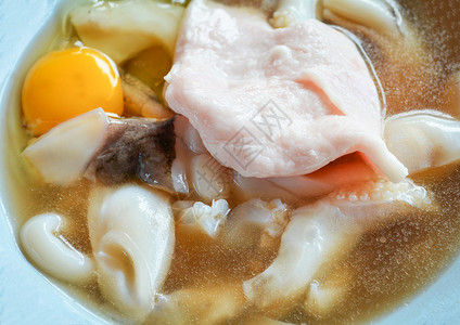 新鲜的鱼叉切片配鸡蛋和猪肉配有酱汁生鱿鱼海鲜做烧烤或Shabu图片