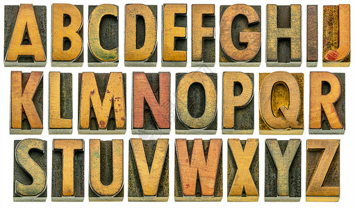 滴墨效果木型英文字母表印刷纸块中26个孤立字母因刮痕和墨污而有许多格按微角拍摄产生3D效果背景