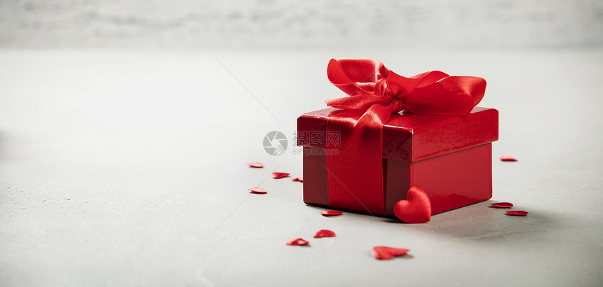 ValentierDay概念在木制背景上贴红弓的礼物情人节盒上贴红弓在生锈背景上绑红色的讽刺丝带弓Valentier日概念图片