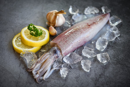 柠檬鱿鱼在冰上生鱿鱼深板背景新鲜乌贼章鱼或餐饮海鲜市场煮熟食品的甲头鱼背景