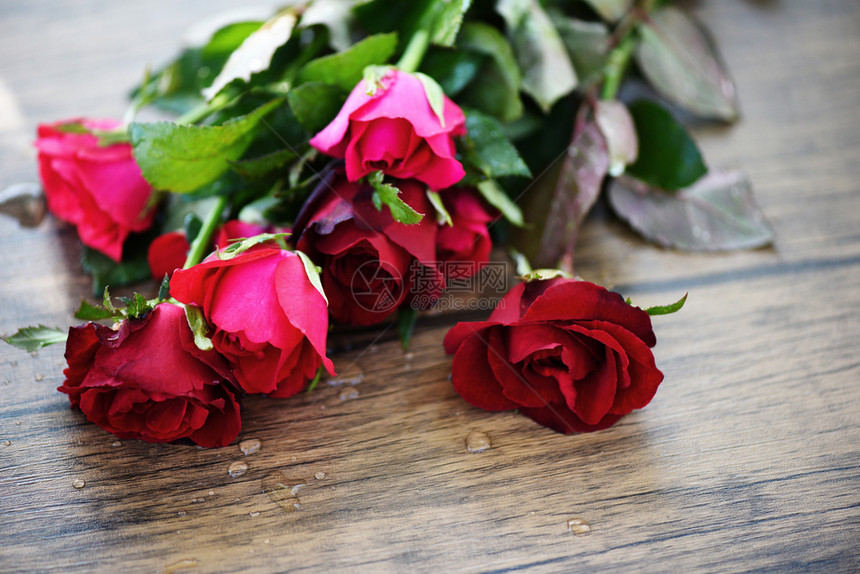红玫瑰花束粉红和玫瑰情人节的爱在木桌的大自然背景上为爱人的概念