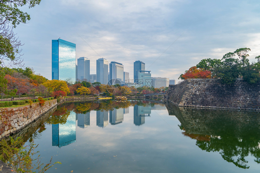 大阪市中心天线有湖或河和摩天大楼位于关西秋天季节多彩有红树叶公园日本城市建筑景观背图片