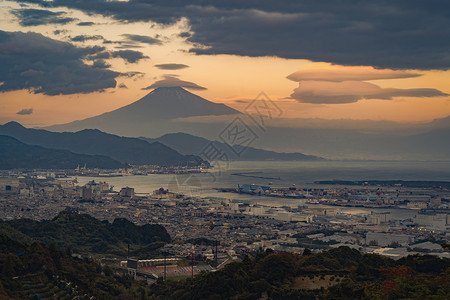 夜交藤日本落时分在本静冈市的港口和在工业区附近有顶云的藤山空中观察背景