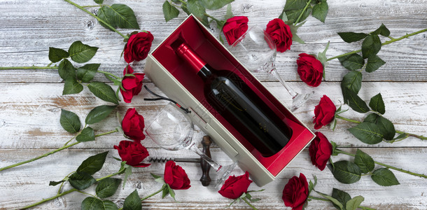 以红玫瑰和一瓶酒庆祝情人节图片