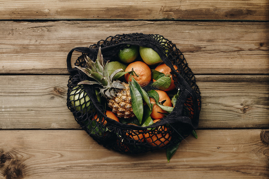 新鲜的季节果实青叶绿苹果和菠萝在木本底平地顶视的生态棉花袋中健康食品零废物生态友好活方式概念新鲜的季节果实绿色叶子苹果和松在生态图片