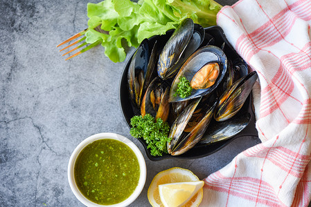 食用含草药柠檬和黑板底新鲜海贝壳鱼在碗上餐室贝壳食品中辣酱沙拉图片