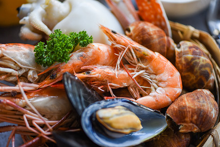 烹饪蒸汽食品为海鲜自助餐概念提供了服务新鲜虾鱿鱼贝发现盘底有比伦贝壳蟹和海鲜酱柠檬食物高清图片素材