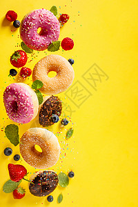 各种装饰的甜圈喷洒着糖和浆果在摇摆不定的背景中落下甜圈在摇摆或飞动中落下背景