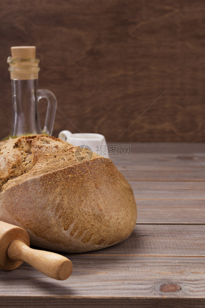 木制背景上的黑麦面包图片