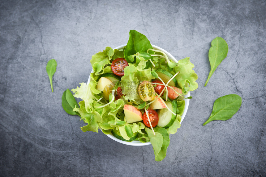 配有水果和新鲜生菜番茄黄瓜健康饮食概念的沙拉蔬菜碗图片