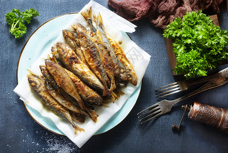 沙丁油鱼炸鱼盐和香料盘背景