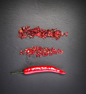 黑色石背景的红辣椒图片