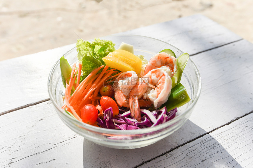 沙拉蔬菜虾水果和新鲜生菜番茄胡萝卜碗上椒餐桌健康饮食概念图片
