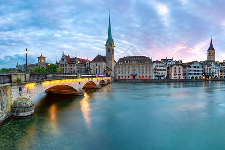 瑞士最大的城市苏黎世老日落时著名的Fraumunster教堂和Munsterbrucke桥在瑞士最大的城市苏黎世Limmat河上芒斯特布鲁克高清图片素材