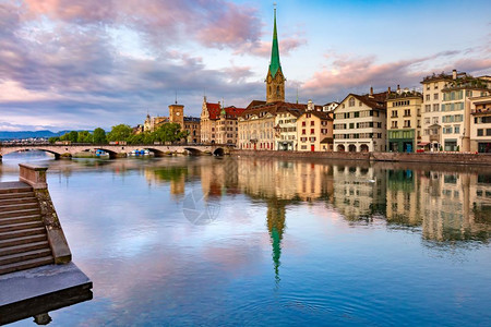 将改革进行到底著名的Fraumunster教堂在瑞士最大的城市苏黎世老的粉红日出时在Limmat河的Limmat河上进行反射苏黎世瑞士最大的城背景
