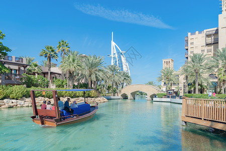 中午阿拉伯朱梅伊岛或装有绿湖河流和反射的造船楼迪拜下城天线阿拉伯联合酋长国或城市阿联酋旅馆的中午行度假概念背景图片