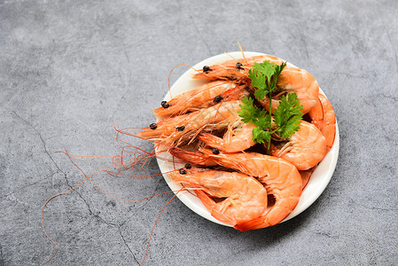 白盘上新鲜虾配有草药椰菜烹饪的海产鲜虾图片