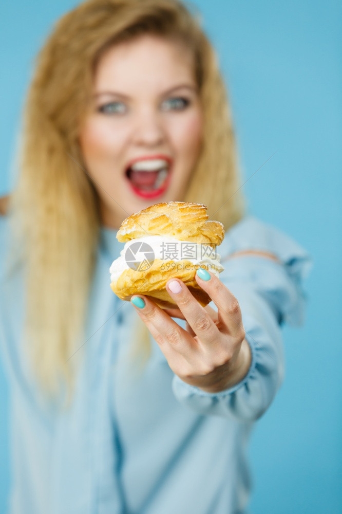 甜美的食物和幸福概念有趣是快乐金发女人拿着美味甜饼蛋糕奶油兴奋的面容表情蓝色的有趣女人拿着奶油蛋糕图片