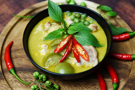 汤碗上泰国菜绿色咖喱配有木板背景绿咖喱鸡烹饪和桌上的饭菜背景图片