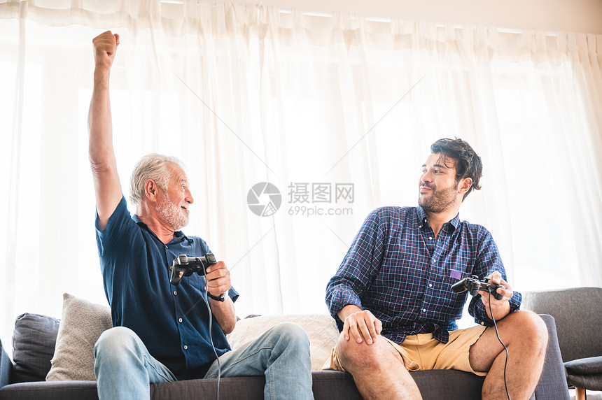 两代快乐双男人家庭老父亲拥抱年轻成儿子享受游戏快乐图片