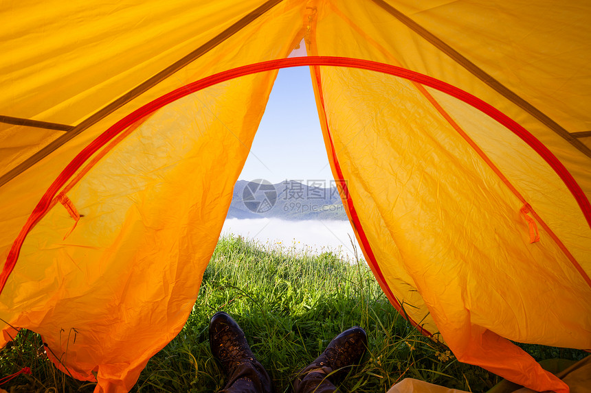 从观光帐篷到山的观光景象穿靴子的人躺在地毯上图片