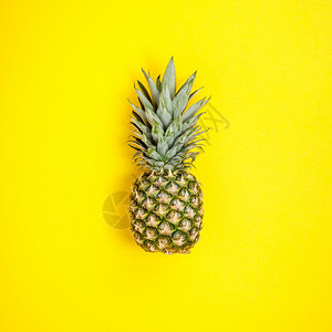 黄色背景的菠萝夏季概念平面顶部视图图片