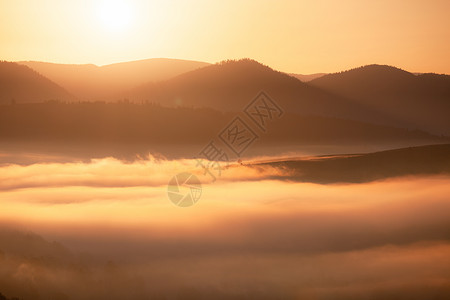 日出山上美丽的雾色风景美好的晨雾秋天山阳光照耀背景图片